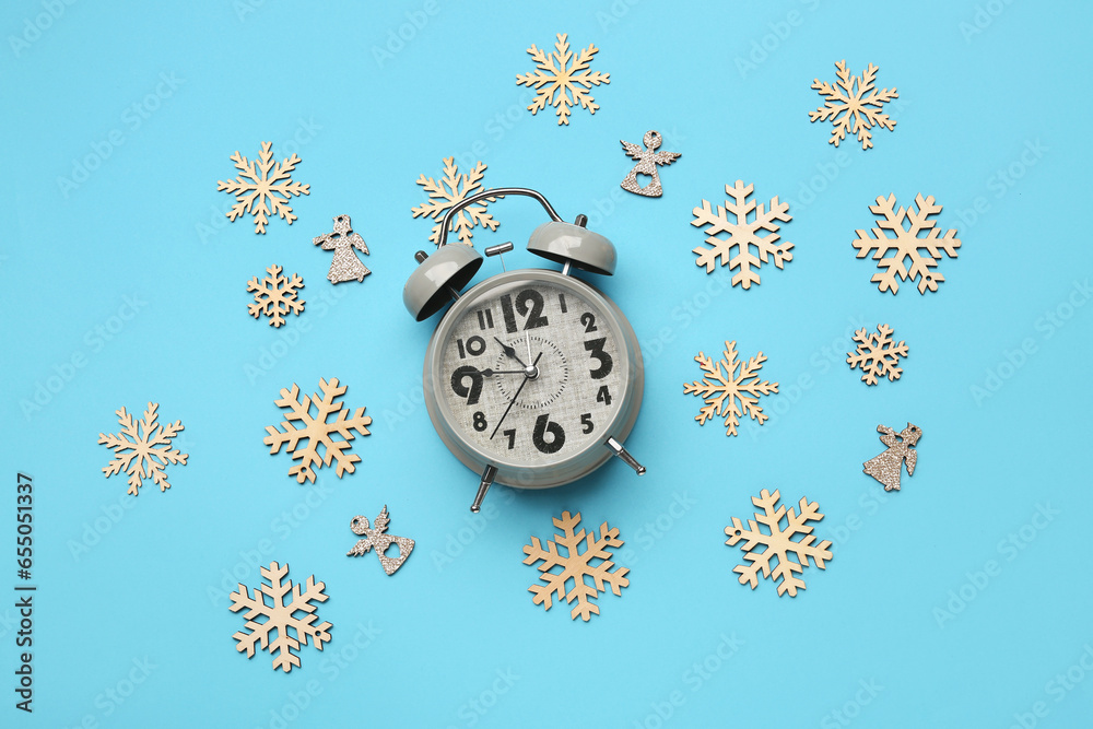 Composition with alarm clock and Christmas decor on color background