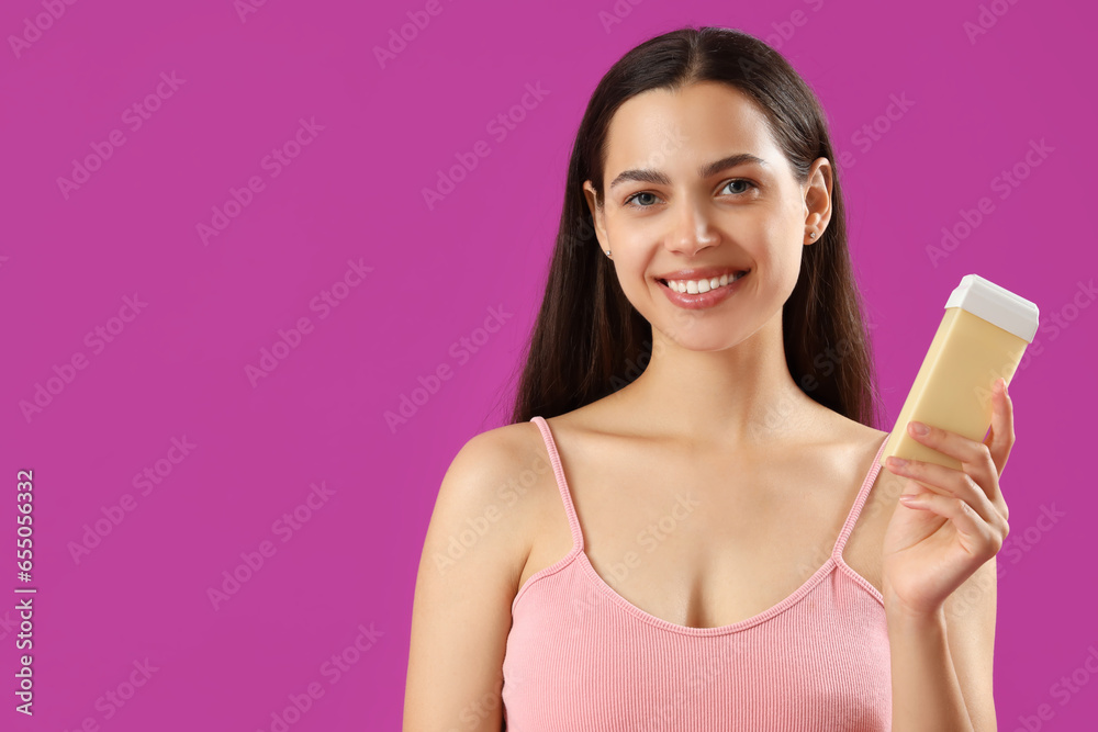 Happy beautiful young woman with liposoluble wax cartridge for epilation on purple background