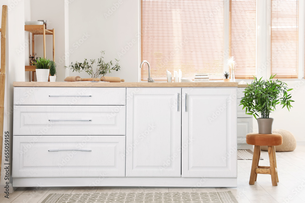 Interior of light kitchen with white counters and carpets