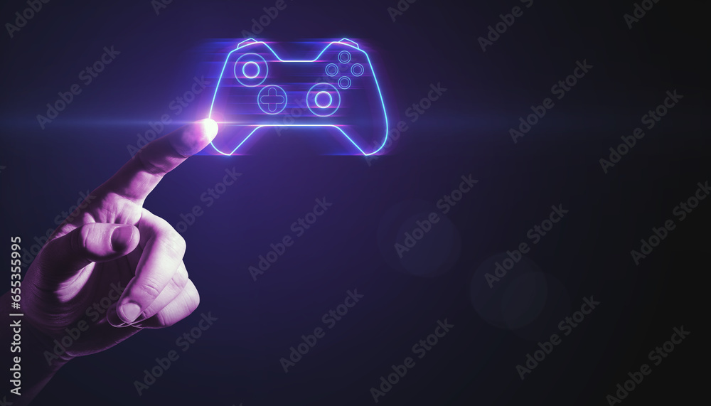 Closeup of businessman hand pointing at creative joystick or gamepad hologram on blurry purple bokeh background. Esport, gaming and fun concept.