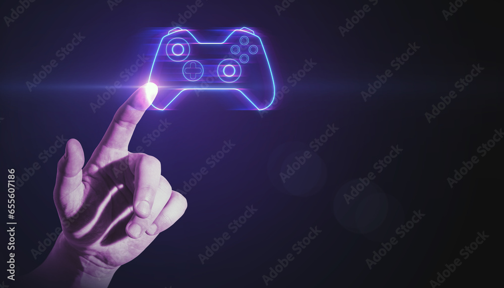 Closeup of man hand pointing at creative joystick or gamepad hologram on blurry purple bokeh background. Esport, gaming and fun concept.