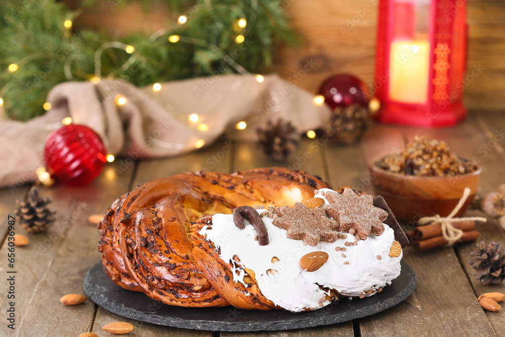 Board with tasty Christmas pastry wreath on wooden table