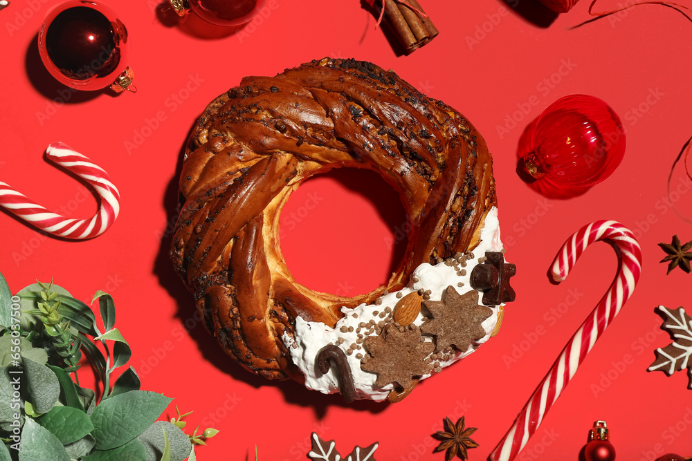 Tasty Christmas pastry wreath, candy canes and decorations on red background