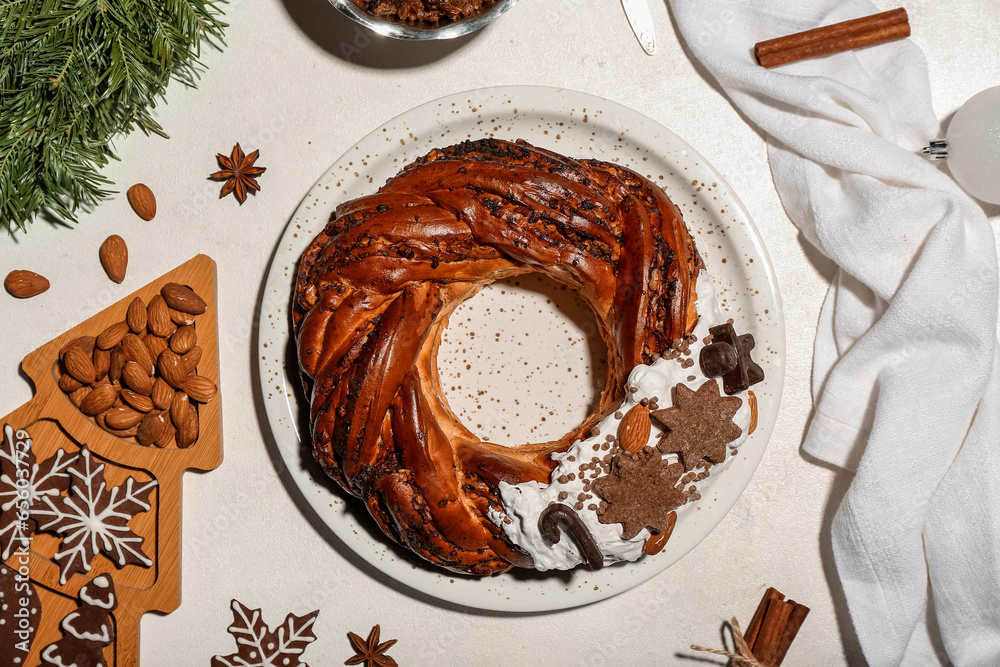 Composition with tasty Christmas pastry wreath, cookies, nuts and spices on light background