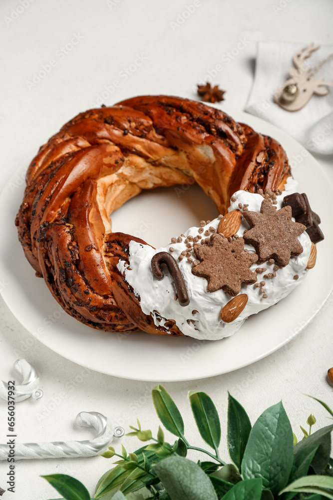 Plate with tasty Christmas pastry wreath on light background, closeup