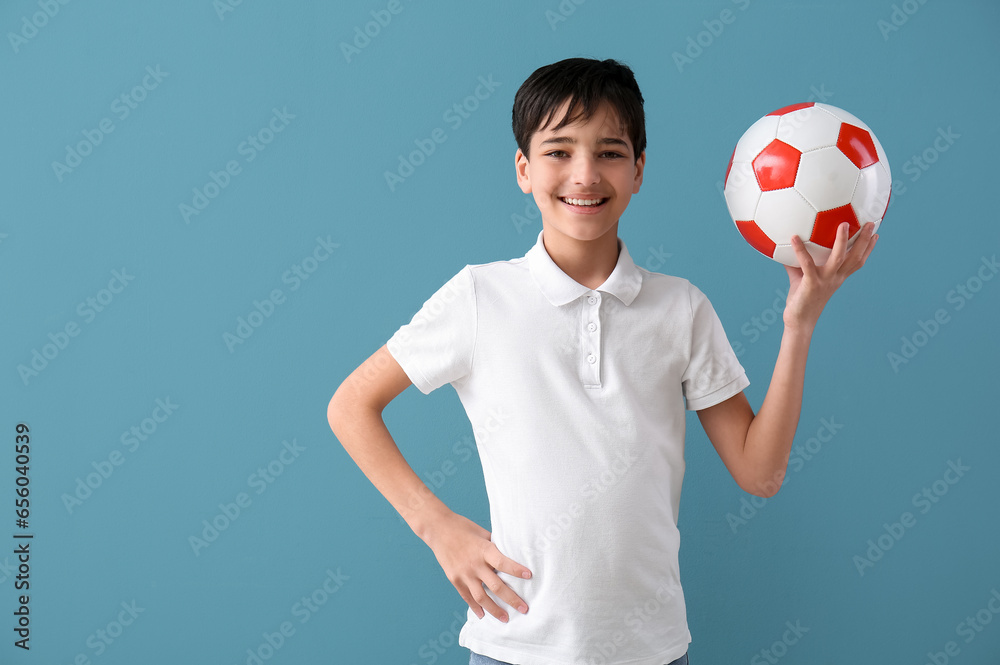 Little boy with soccer ball on blue background