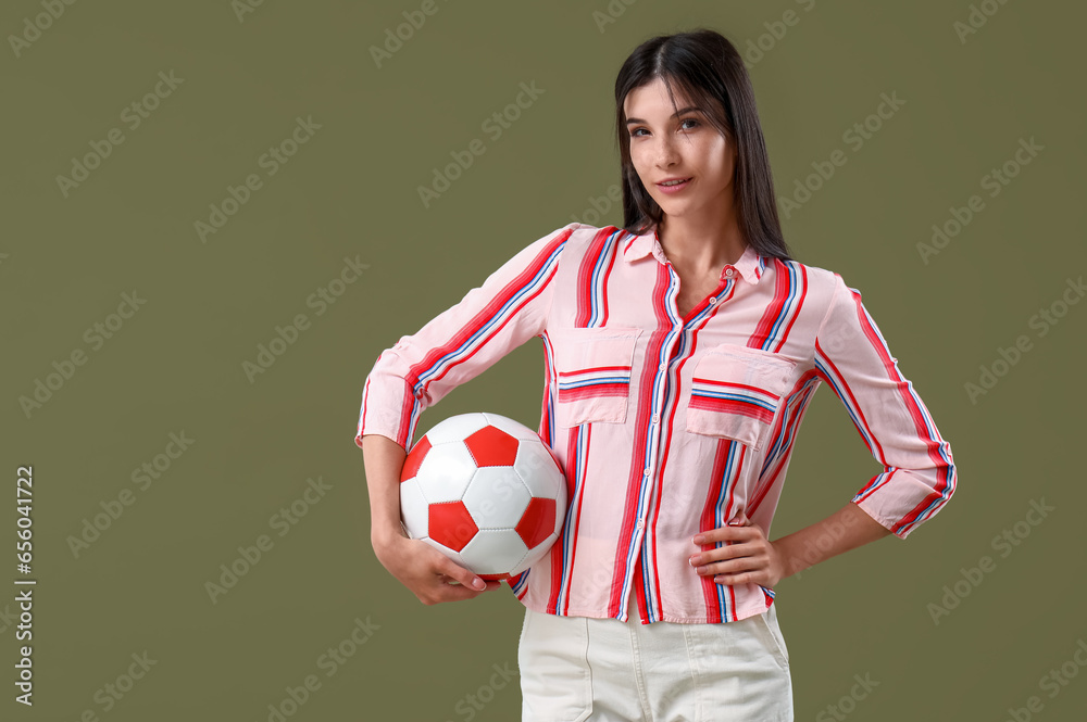 Young woman with soccer ball on color background