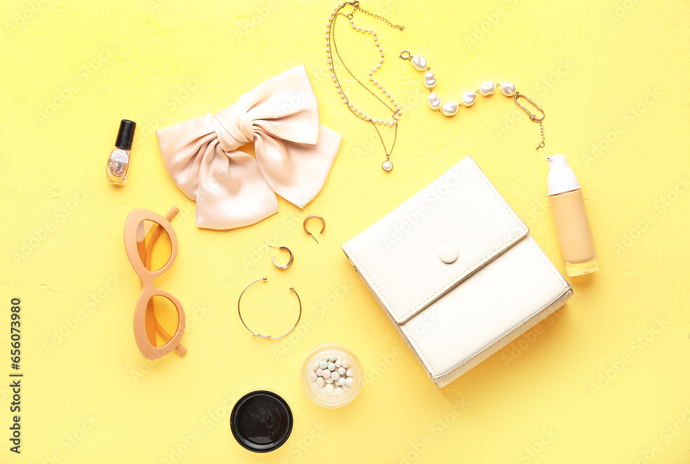 Composition with stylish female accessories and cosmetics on yellow background