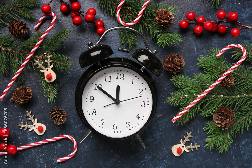 Alarm clock and candy canes, Christmas tree branches with rowan on blue background