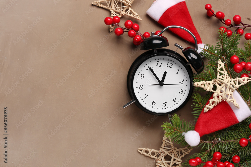 Alarm clock and Santa hats, Christmas tree branches with rowan on brown background