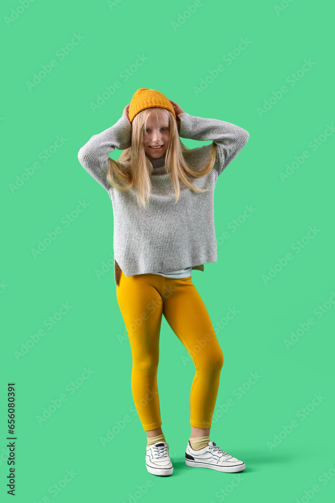 Little girl in hat on green background