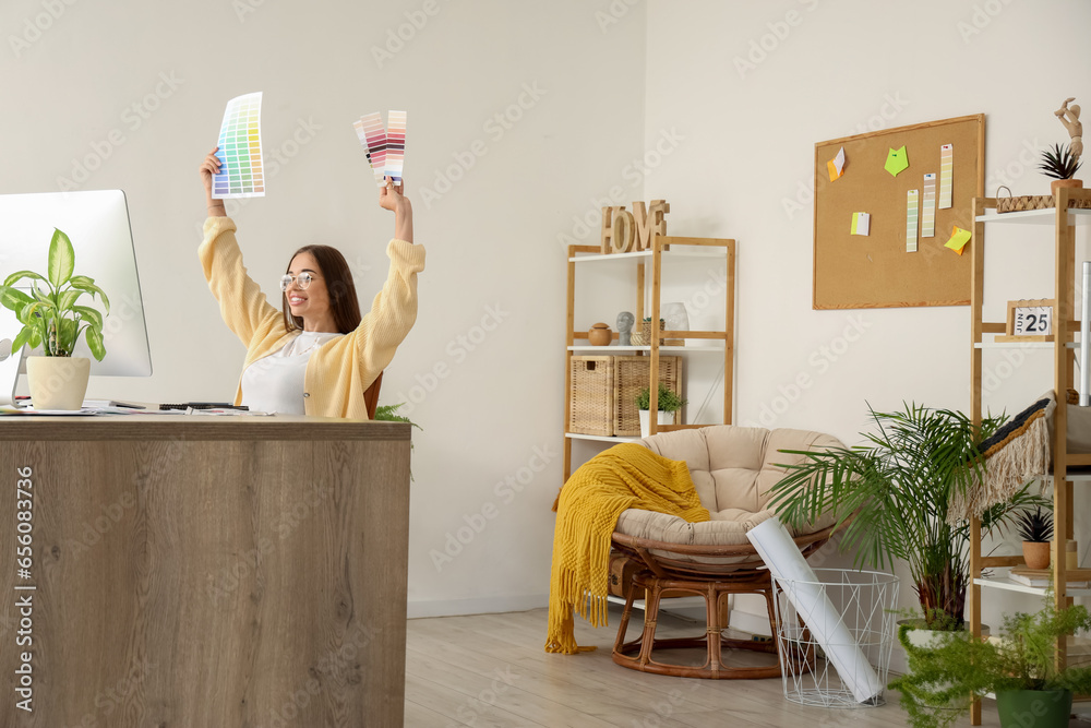 Female interior designer working with color palettes at table in office