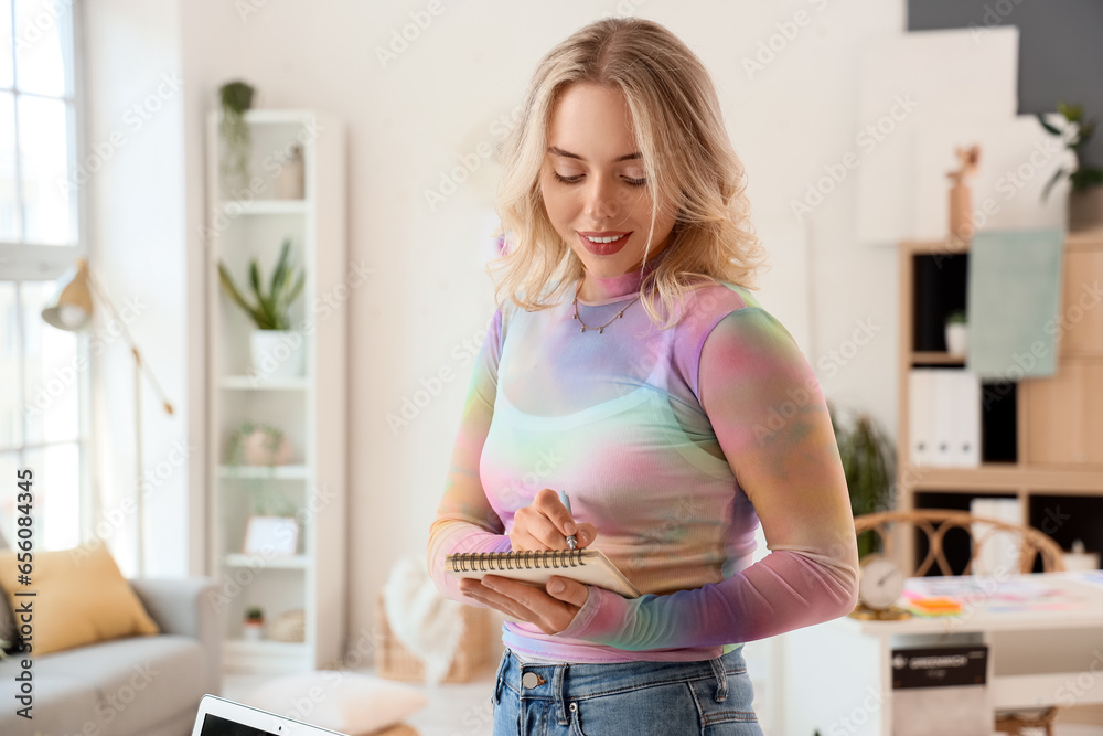 Female interior designer with notebook in office