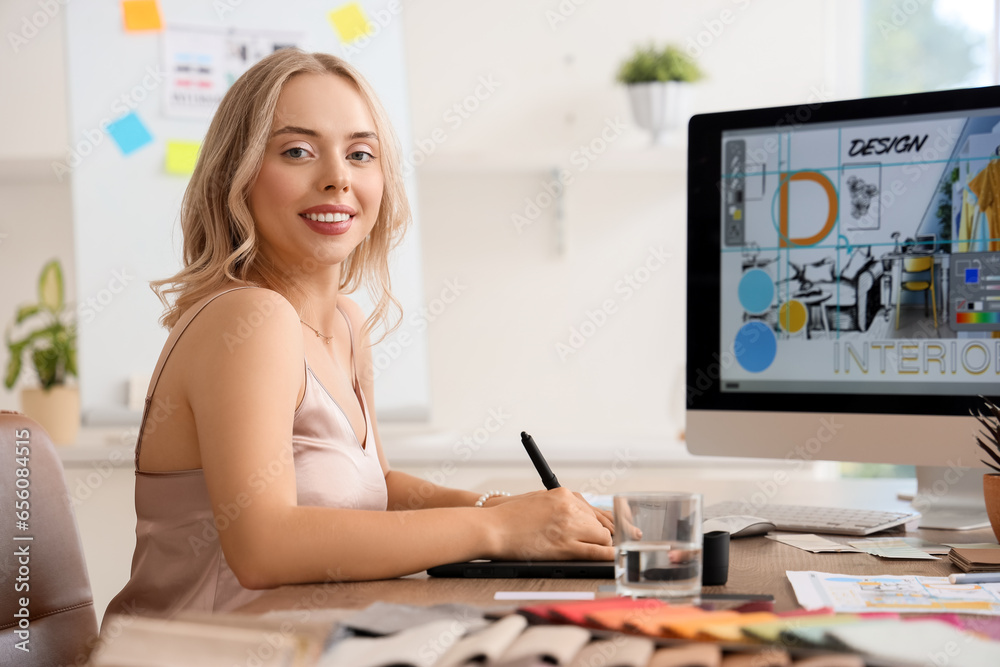 Female interior designer working with graphic tablet at table in office