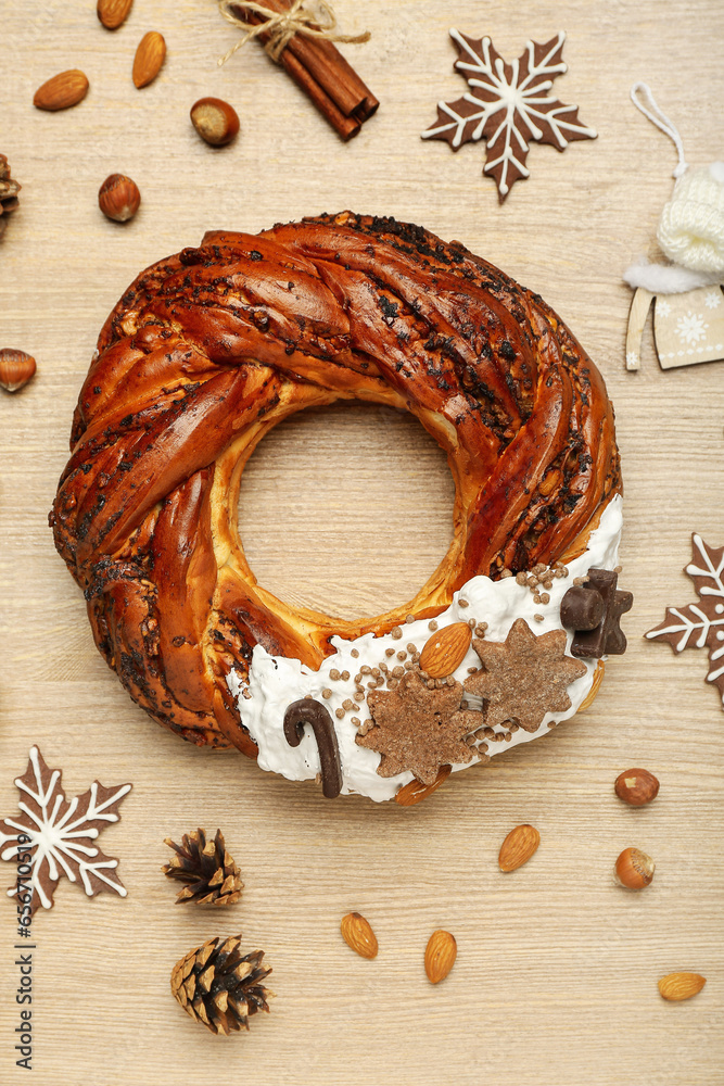 Tasty Christmas pastry wreath, nuts and cookies on wooden background