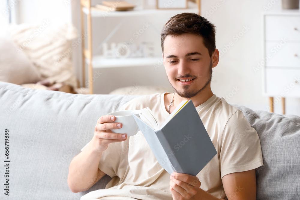 Young man reading book on his day off at home