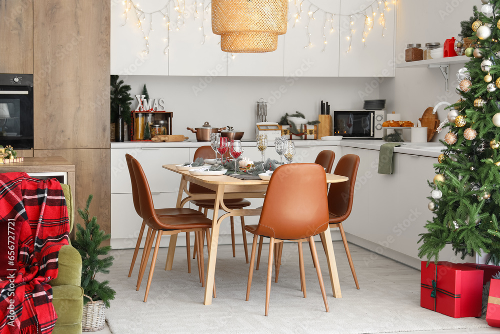 Interior of modern kitchen with Christmas decorations and festive table setting