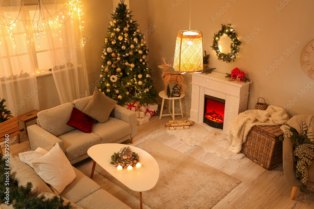 Interior of festive living room with Christmas tree, fireplace and sofas