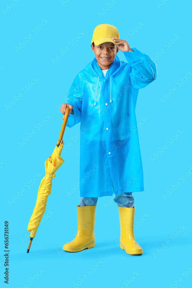 African-American little boy with umbrella on blue background