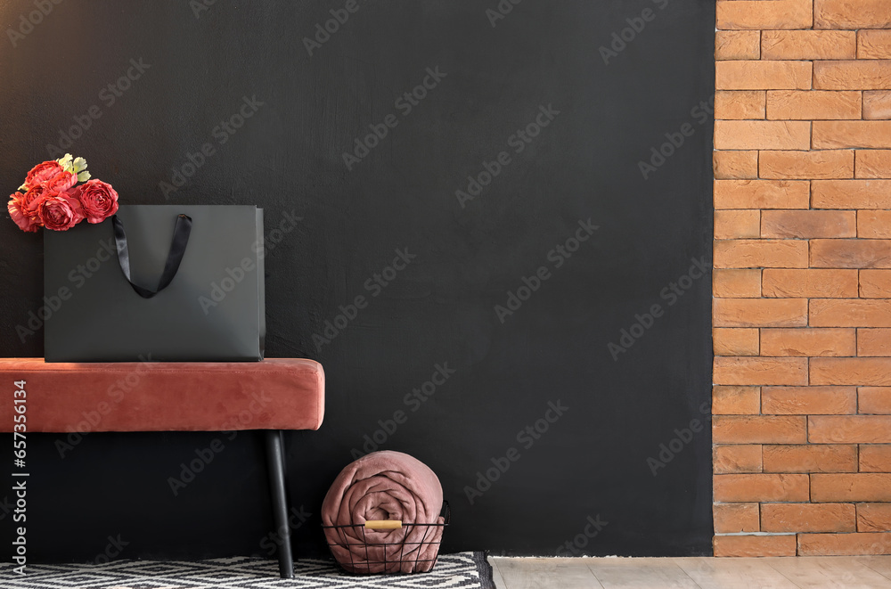 Shopping bag with flowers on pink bench in stylish room