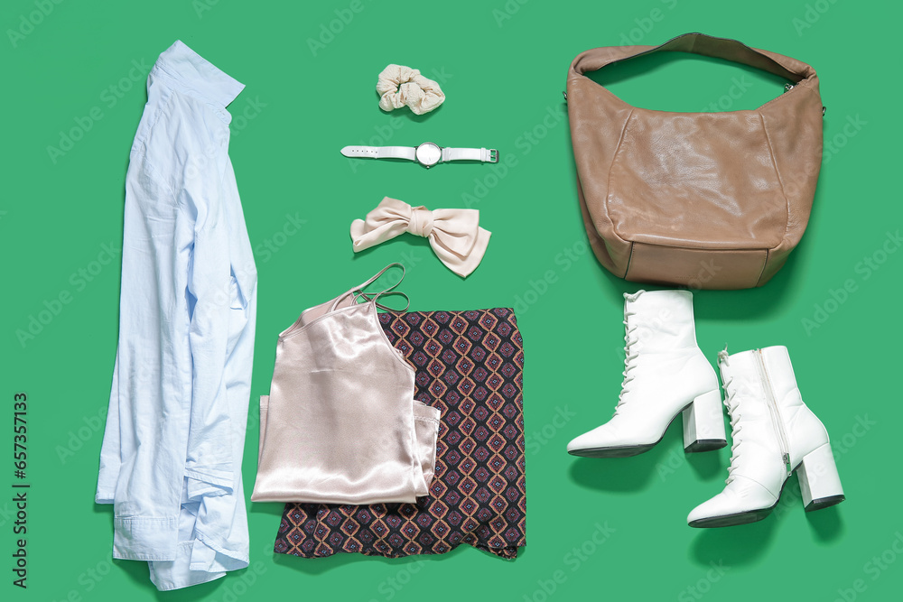 Composition with female clothes, shoes and accessories on green background