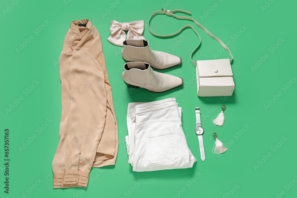 Composition with stylish female accessories, shoes and clothes on green background