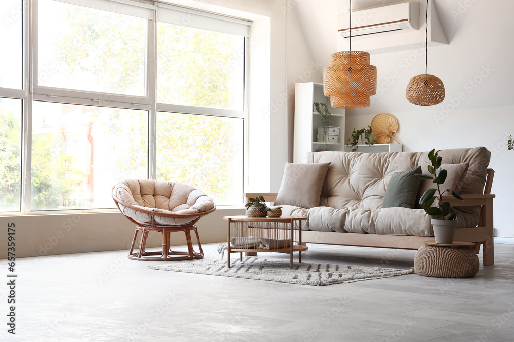 Interior of light living room with sofa, armchair and table