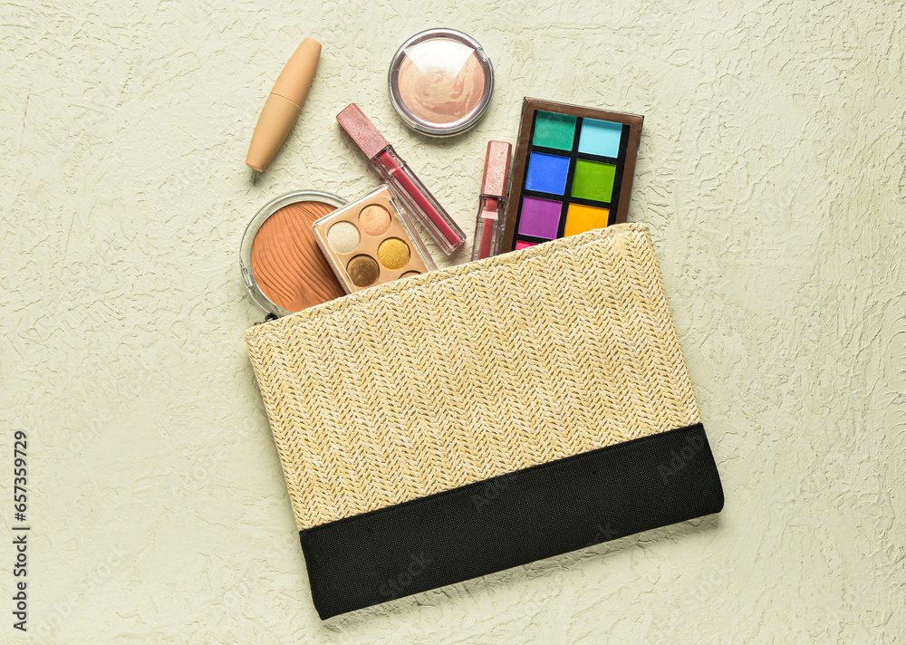 Wicker bag with decorative cosmetic products on textured beige background