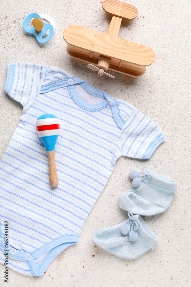 Composition with baby clothes and accessories on light background