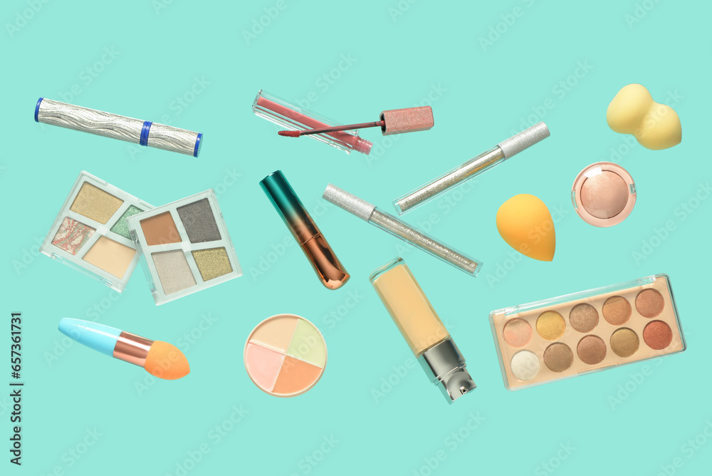 Different flying decorative cosmetics on color background