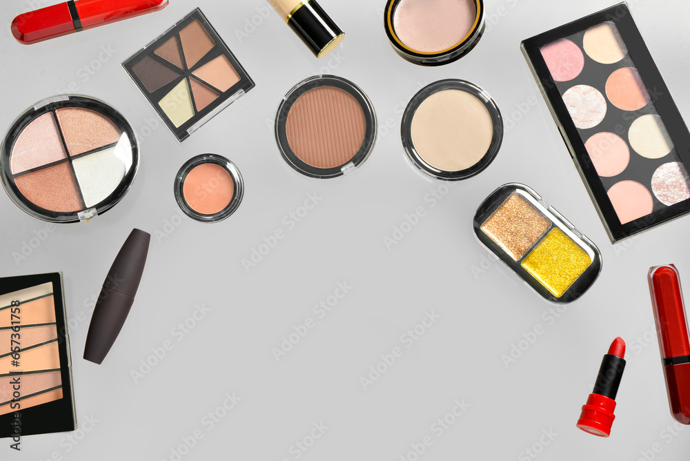 Different decorative cosmetics flying on grey background