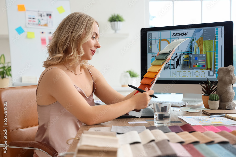 Female interior designer working with fabric samples at table in office