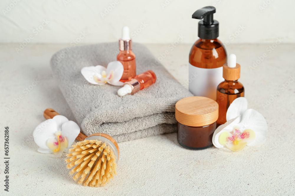 Composition with cosmetic products, bath supplies and orchid flowers on light background