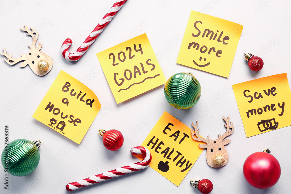 Sticky notes with different goals for 2024 and Christmas decorations on white background