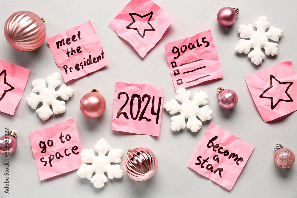 Sticky notes with different goals for 2024 and Christmas decorations on grey background