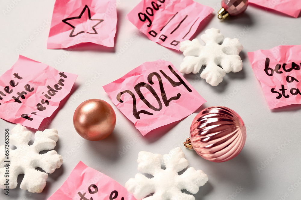 Sticky notes with different goals for 2024 and Christmas decorations on grey background