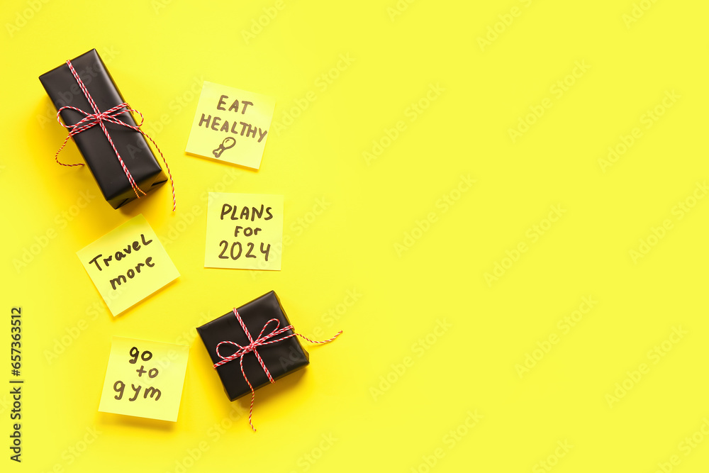 Sticky notes with different goals for 2024 and gift boxes on yellow background