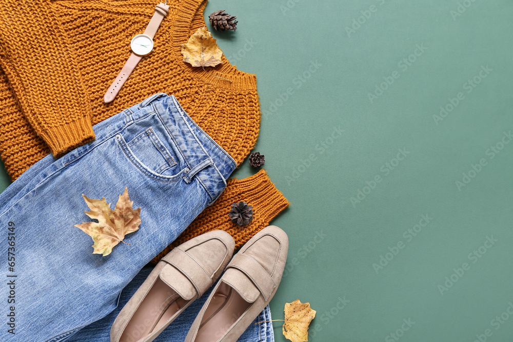 Composition with stylish female clothes, shoes and fallen leaves on color background