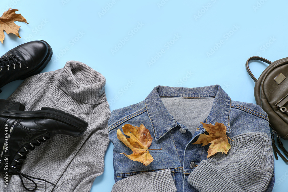 Set of stylish female clothes, accessories and autumn leaves on color background