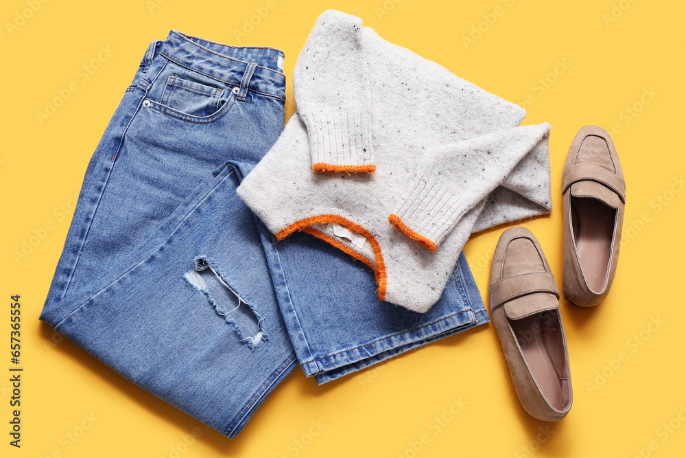 Set of stylish female clothes and shoes on yellow background