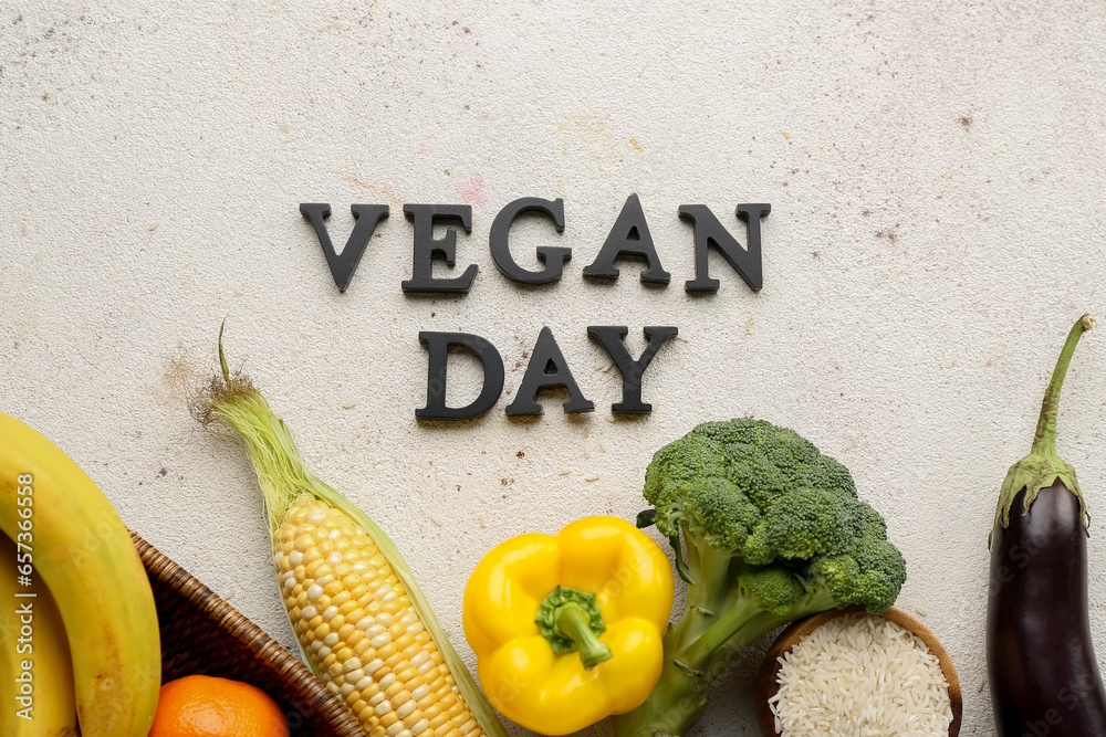 Text VEGAN DAY and different healthy products on white background