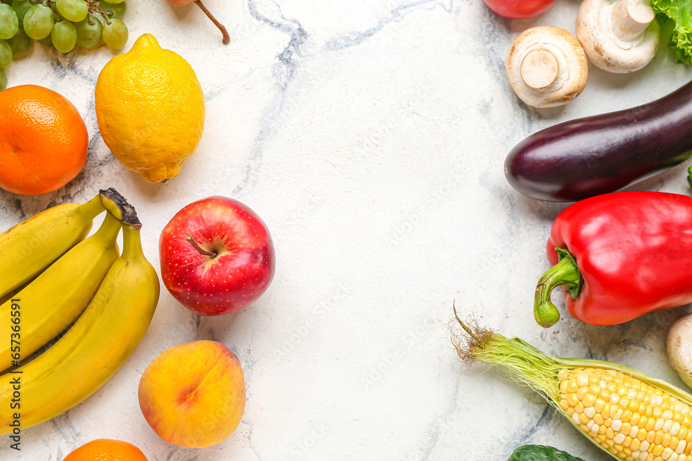 Frame made of fresh vegetables and fruits on white marble background. World Vegan Day concept