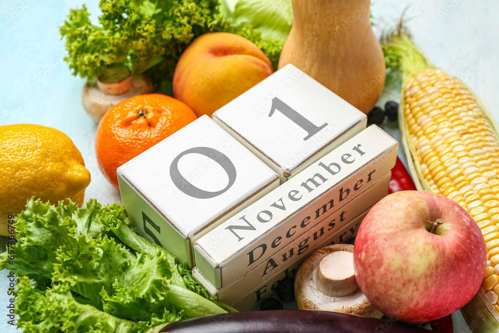 Fresh vegetables, fruits and cube calendar with date NOVEMBER 1 on blue background. World Vegan Day concept