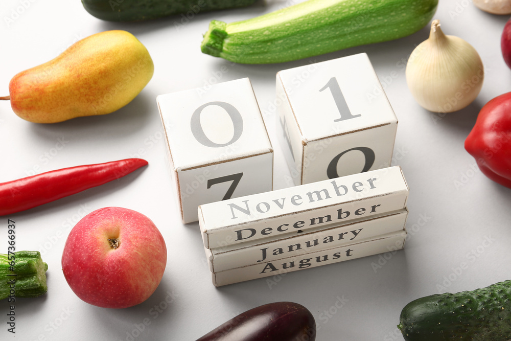 Fresh vegetables, fruits and cube calendar with date NOVEMBER 1 on grey background. World Vegan Day concept