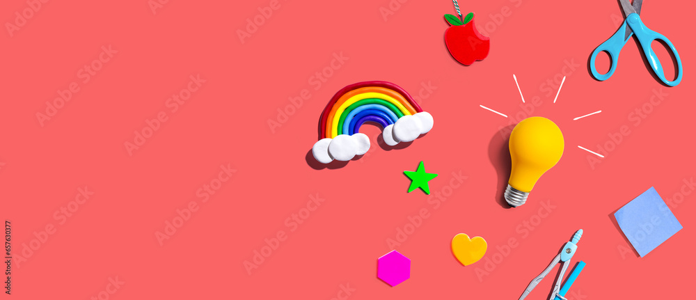 Idea light bulb with a rainbow and school supplies overhead view - flat lay