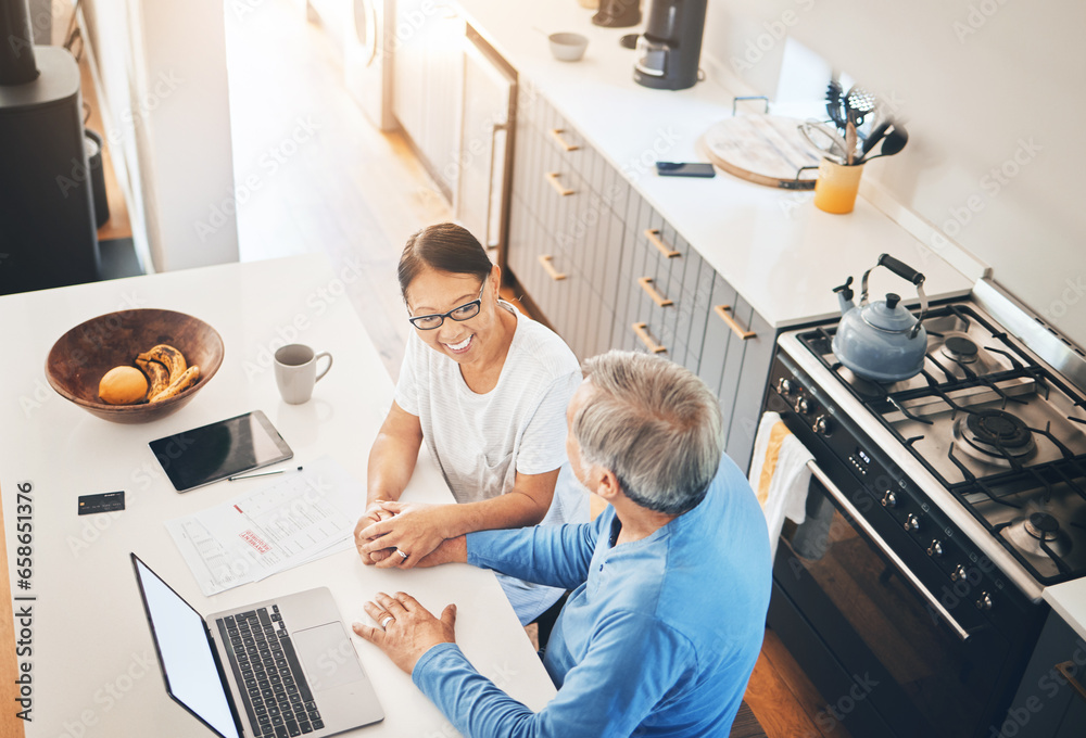 Couple, laptop and home documents for finance, loan payment and mortgage planning, support and love in kitchen. Mature woman and man holding hands for banking and paperwork solution on computer above