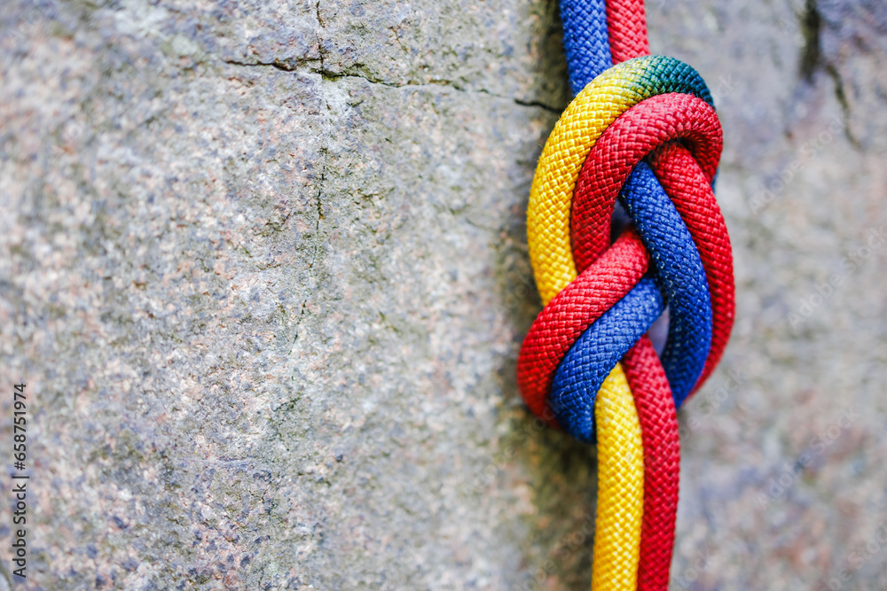 eight climbing knot with colorful rope on rocky background