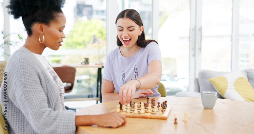 Girl friends playing chess in the living room for bonding, entertainment or having fun together. Happy, smile and young interracial women enjoying board game in the lounge of modern apartment.