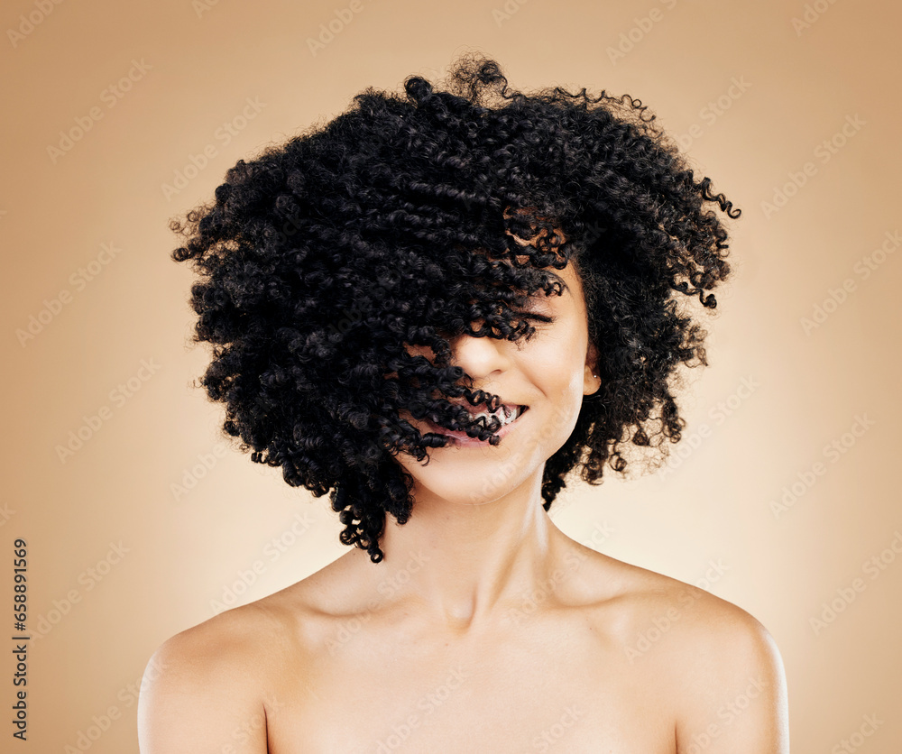 Woman, curly and hair wind in afro fun on studio background for healthy hairstyle growth, texture and frizz treatment. African beauty model, shake energy and change by shampoo transformation results