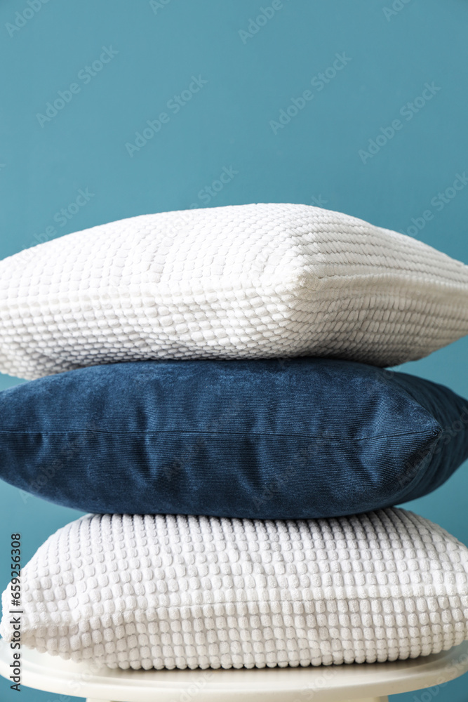 Stool with cushions near blue wall